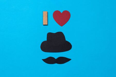 Black hat, mustache and red heart made of paper on blue backgroundの写真素材