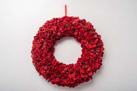 A decorated red Christmas wreath with Christmas balls and ornaments on white backgroundの写真素材