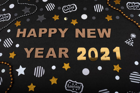 Happy new year made from wooden letters and 2021 made from golden numbers, golden and silver stars,...