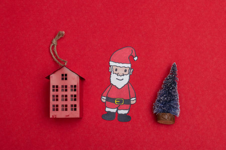 Little red house, Smiling Santa Claus and little christmas tree on red background. Christmas...