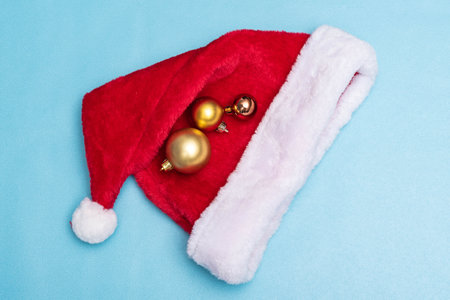 Santa Claus hat and christmas balls on blue background. Christmas decorationの写真素材