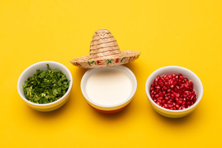 Coriander, cream, pomegranate and little hat on yellow backgroundの写真素材