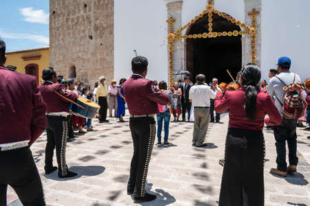 TLACOLULA, OAXACA, MEXICO- MAY 23, 2022: Mariachi playing outside of Parroquia Santa Maria de la Asuncion at a sunny day in Tlacolula, Oaxaca, Mexicoのeditorial素材