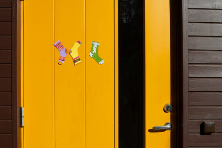 Paper socks of different colors hang on the door. World Down Syndrome Day. Sunny spring day.