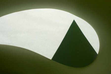 Macro image of green paper with shadow effect and selective focus. Abstract geometric background....