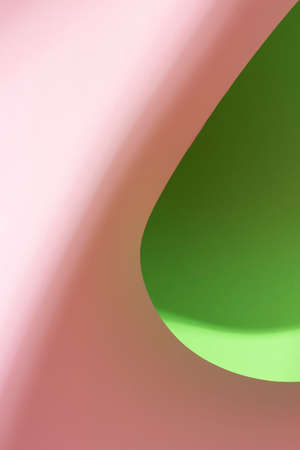 Colour paper geometric shape. Green and pink paper with shadow effect and selective focus. Abstract background. Copy space.の写真素材