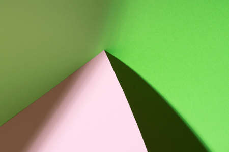 Colour paper geometric shape. Green and pink paper with shadow effect and selective focus. Abstract background. Copy space.の写真素材