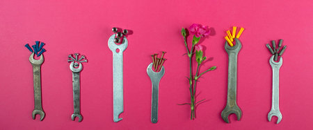 Labor Day background concept, 1 May concept. Wrench and clove pink carnation flower on pink...