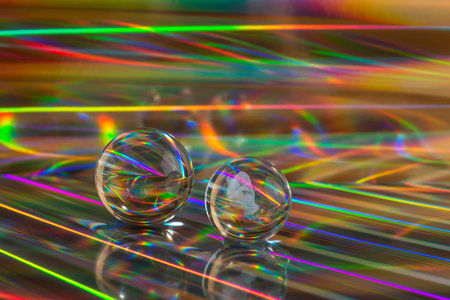 Glass crystal balls on abstract holographic background close up.Â Bright vibrant abstraction.