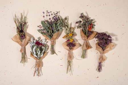 Dried herb bundles of different herbs on handmade paper background. Flat lay, top view.の写真素材