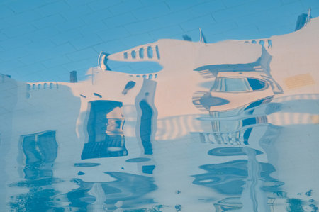 Pool water with hotel building reflections. Distorted, blurred, abstract view. Vacations concept.の写真素材
