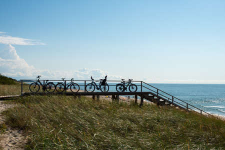 The silhouette of bikes standing in a row on the Baltic Sea coast. Vacation concept.の写真素材