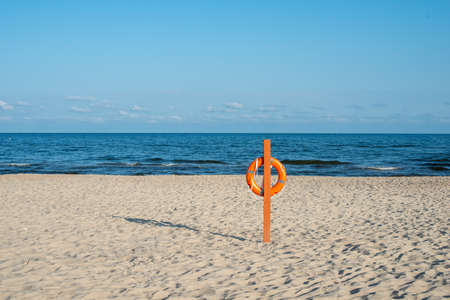 Lifebuoy on an empty sandy beach by Baltic sea in Lithuania. Minimalist landscape.の写真素材