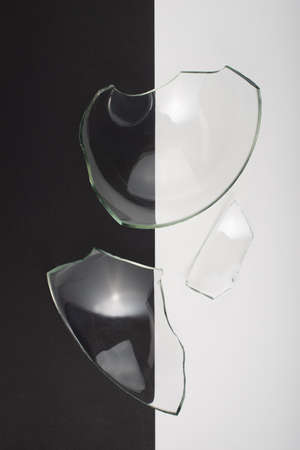 Broken glass pieces on black and white background. Close up, top view.の写真素材
