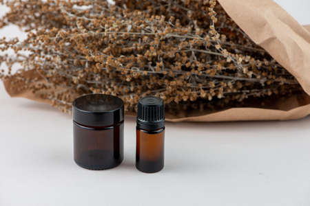 Dried Wormwood herb, Artemisia absinthiu, and glass bottles close up.の写真素材