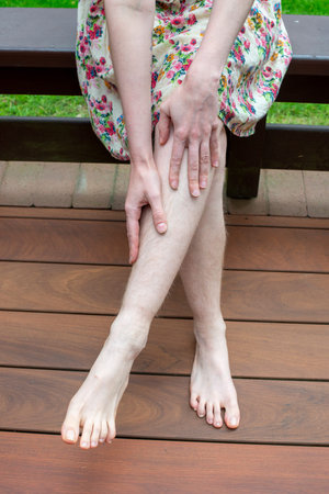 Natural unshaved hairy legs of a body positive young woman.