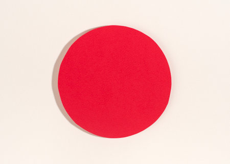 Red paper circle with shadow on white background.の写真素材