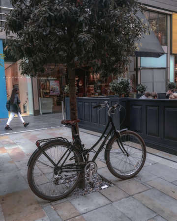 Woman walking by a bike in Londonのeditorial素材