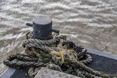 Close up of a rope tied to an anchor point on the riverの写真素材