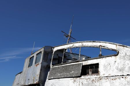 The derelict boat  moored on the River Thames showing the cross sail mastの写真素材