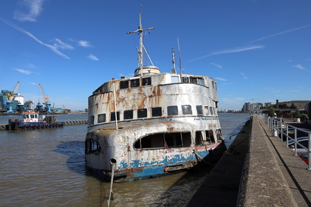 The derelict boat the HMS Iris moored on the River Thames and tug boatのeditorial素材