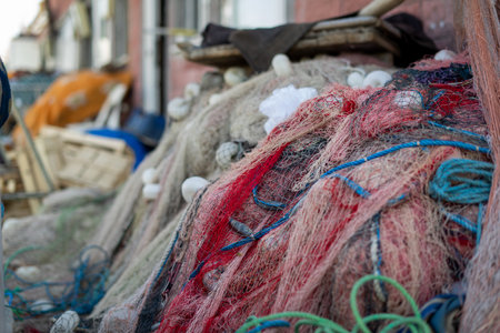 Stacked fishing nets and ropes red green and white thick and thinの写真素材