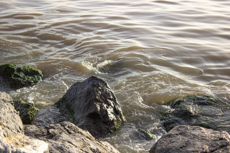 Sea waves crash against rocks with foam