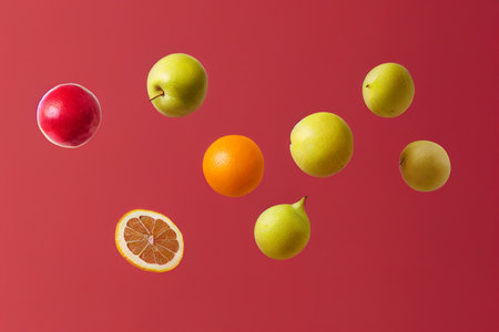 Falling fruits isolated on a red background. Healthy food concept.の写真素材