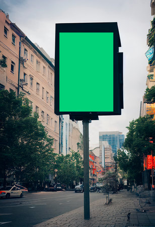 Blank green billboard on the city street with buildings in the backgroundの写真素材