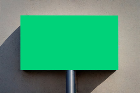 Blank green signboard on concrete wall. Mockup for designの写真素材