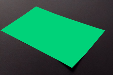 Blank green business card on black background. Mockup for branding identity.の写真素材