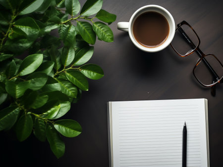Office desk table with coffee cup, notebook, glasses and plant. Top view with copy spaceの写真素材