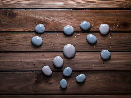 Spa stones on a wooden background with drops of water, top viewの写真素材