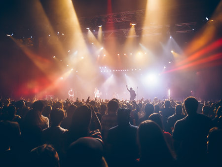 Crowd at a concert in front of a bright stage lights.の写真素材