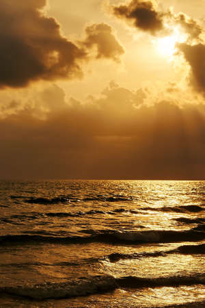 Golden sunset on pacific sea with cloudsの写真素材