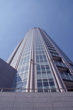 Corporate multi-storey building - a tower on a background of the dark blue sky in a bright sunny day