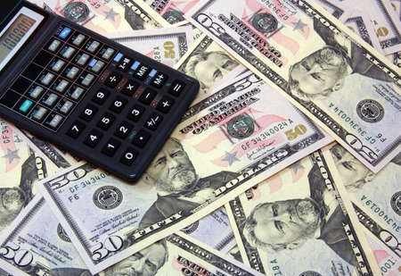 The calculator atop of dollar banknotes for backrounds and otherの写真素材