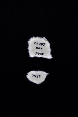 Happy New Year written on a piece of white paper on a black background