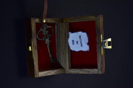 Old key in a wooden box on a dark background with a noteの写真素材