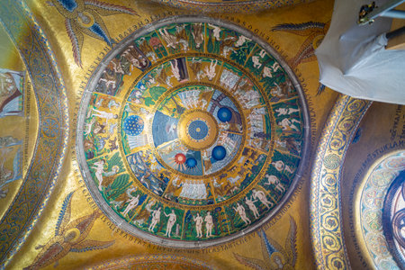 Golden mosaics and intricate frescoes adorn the interior of a historic basilica, showcasing religious art and marble columns under soft natural light.の写真素材