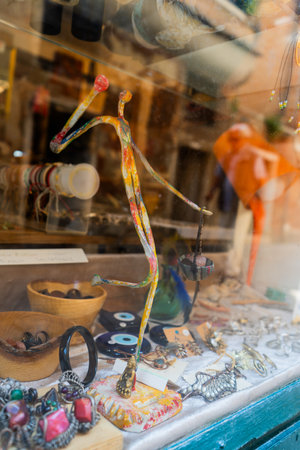 A vibrant abstract sculpture with colorful patterns displayed in a shop window, surrounded by jewelry, trinkets, and decorative items.の写真素材