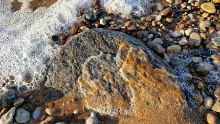 Foamy Sea Water Washing Over Rocky Coastal Surfaceの写真素材