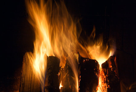 billets burning in flames in fire place to heat the living room