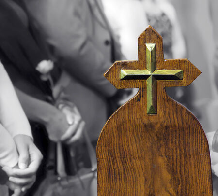 Metallic cross on pew, believers in church の写真素材