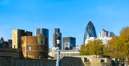 Tower wall and skyscapers in London against cloudless sky.