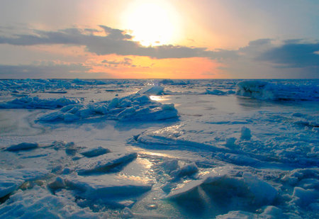 Ice accumulation on frozen  Baltic sea in sunset.