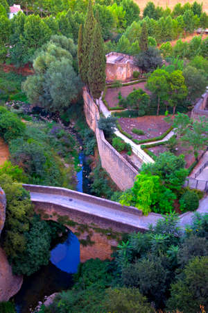Ancient Arab stone walls with bridge and river in Ronda village, Andalusia, Spain.の写真素材