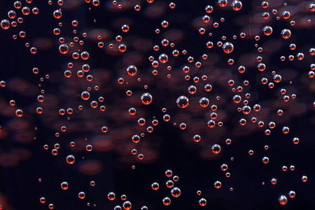 Micro-bubbles sparkling in red light, natural pattern.の写真素材