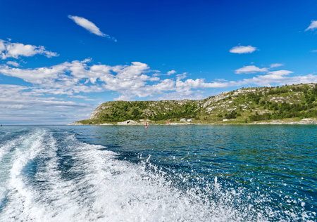 Scenery of Norwegian Sea in beautiful summer day with motor boat trail.の写真素材