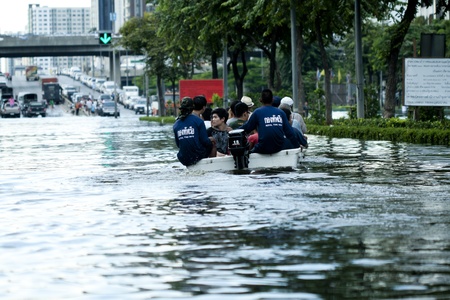 bangkok - october 28: going home on small plastic boat during the flood water on pra pin klow bridgr in bangkok, thailand on oct. 28, 2011. the area is on the west side of the chaopraya river のeditorial素材
